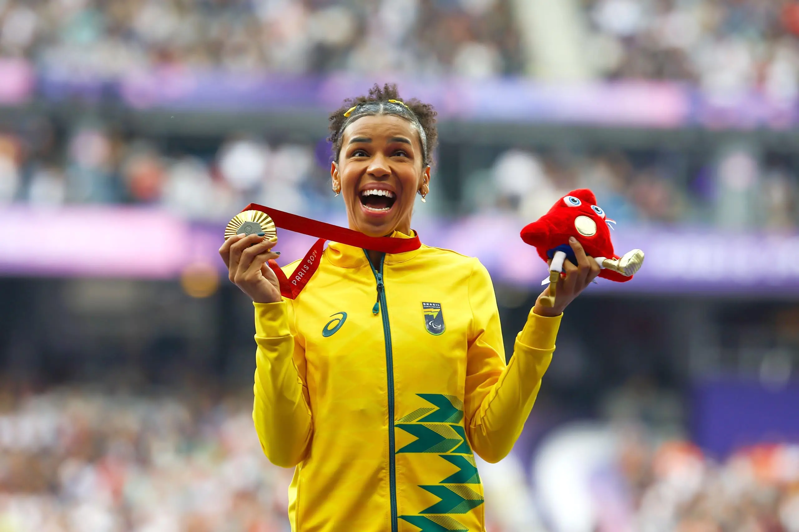 imagem mostra atleta segurando medalha