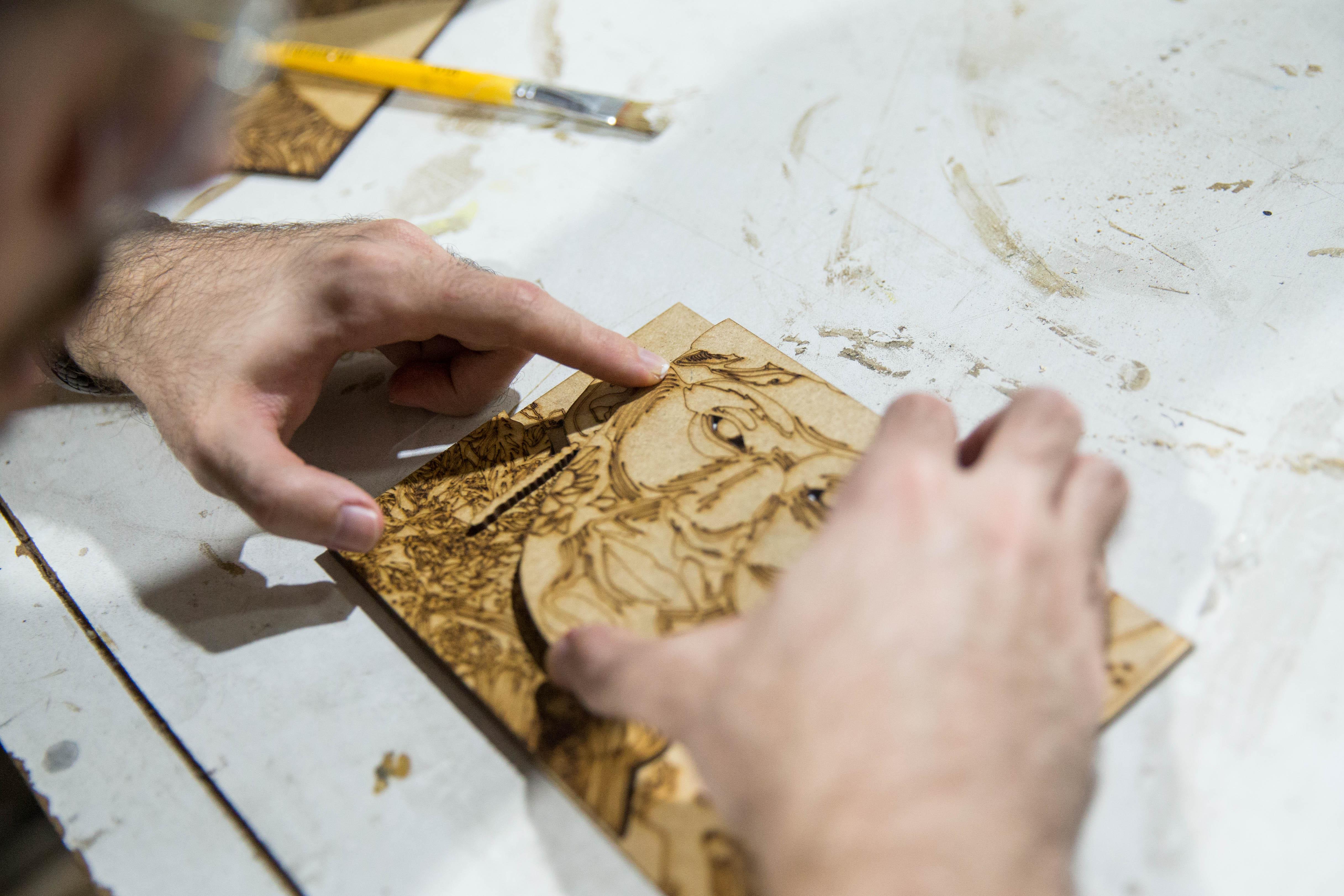 Homem colando a peça tátil