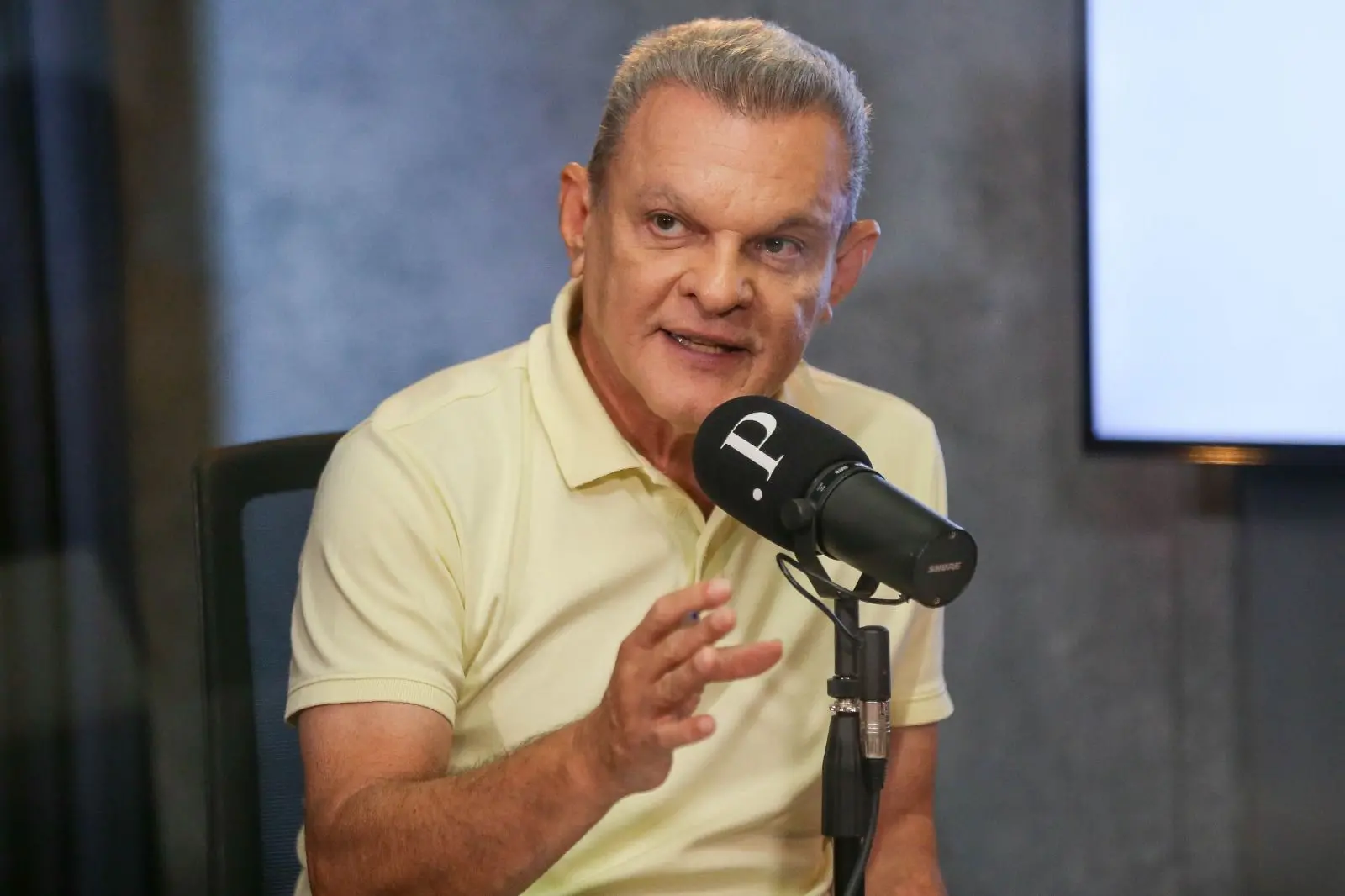 José Sarto é um homem branco, idoso, de cabelos grisalhos. Na foto, ele usa uma camisa polo amarela