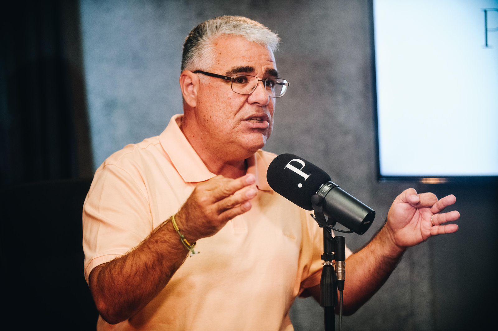 Eduardo Girão é um homem de meia idade e cabelos grisalhos. Na foto, ele usa uma camisa polo laranja