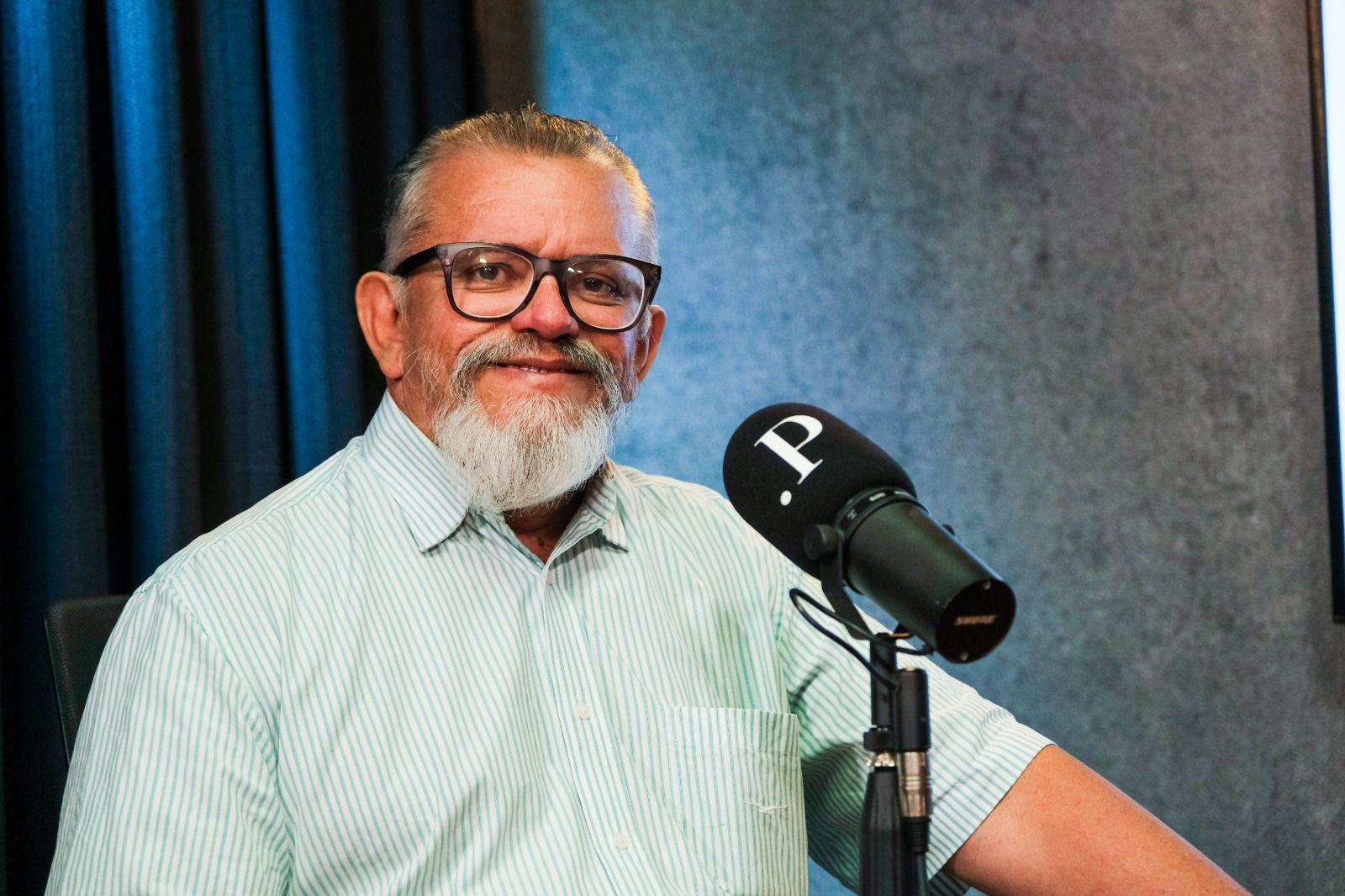 Chico Malta é um homem idoso de barba espessa grisalha e cabelo também grisalho. Na foto, ele está de camisa de botão verde listrada