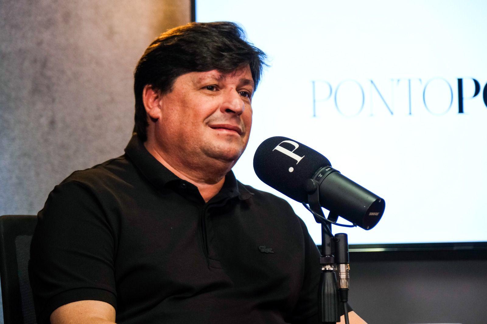 George Lima é um homem branco de meia idade e cabelo preto liso. Na foto, ele está de camisa polo preta