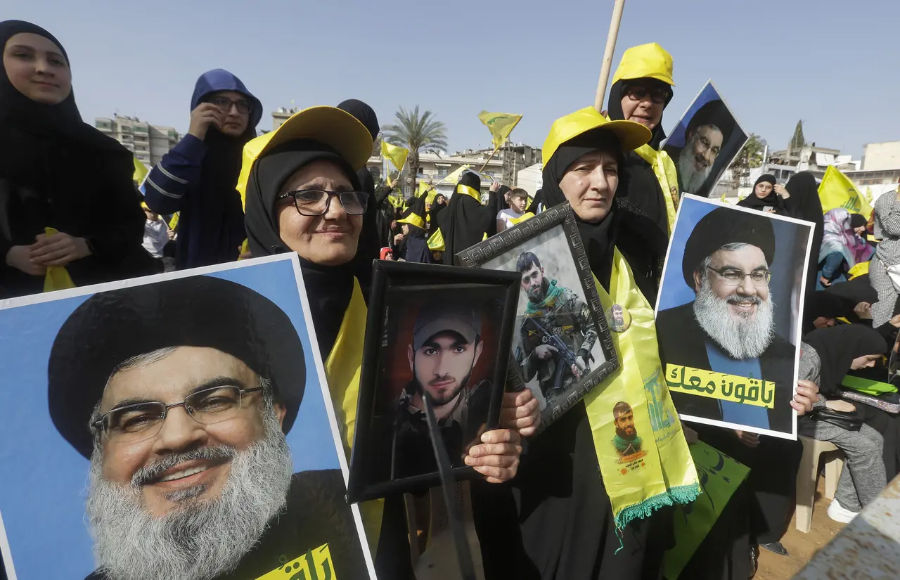 Apoiadores do grupo xiita libanês Hezbollah, apoiado pelo Irã, erguem retratos do líder do grupo, Hassan Nasrallah, enquanto se reúnem para assistir ao seu discurso