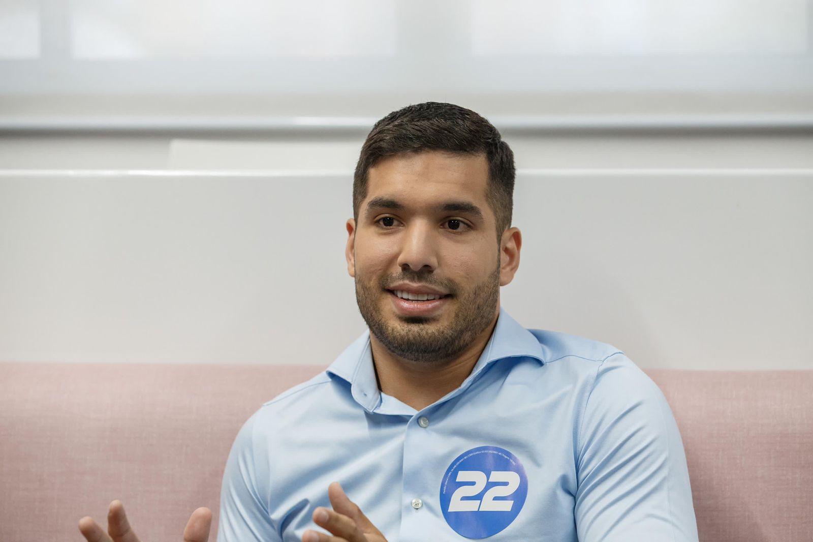 André Fernandes é um homem branco de cabelo curto preto. Na foto, ele está de camisa azul de botão