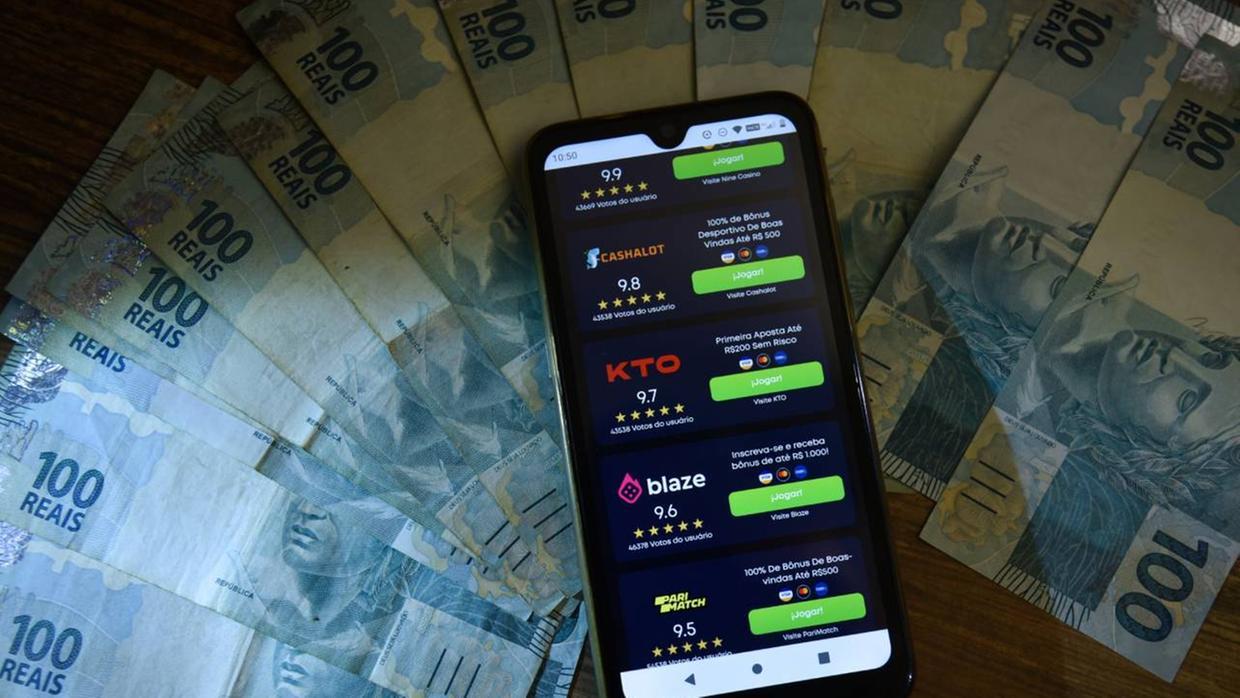 Celular sobre leque de dinheiro