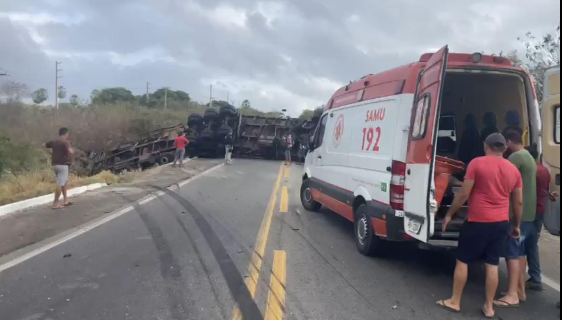print de vídeo mostra ambulancia em primeiro plano e carreta tombada em rodovia, ao fundo
