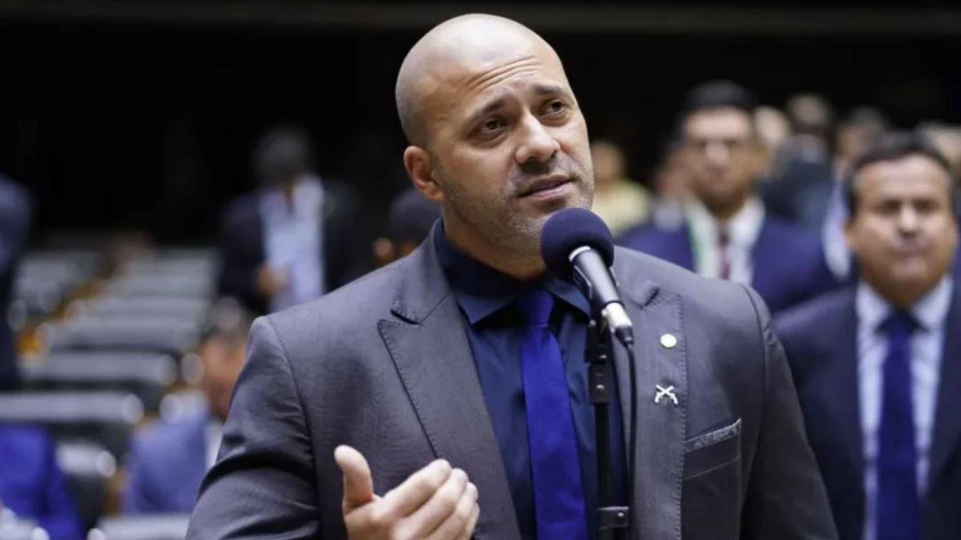 daniel silveira falando em microfone no plenário da câmara dos deputados. ele usa terno e gesticula