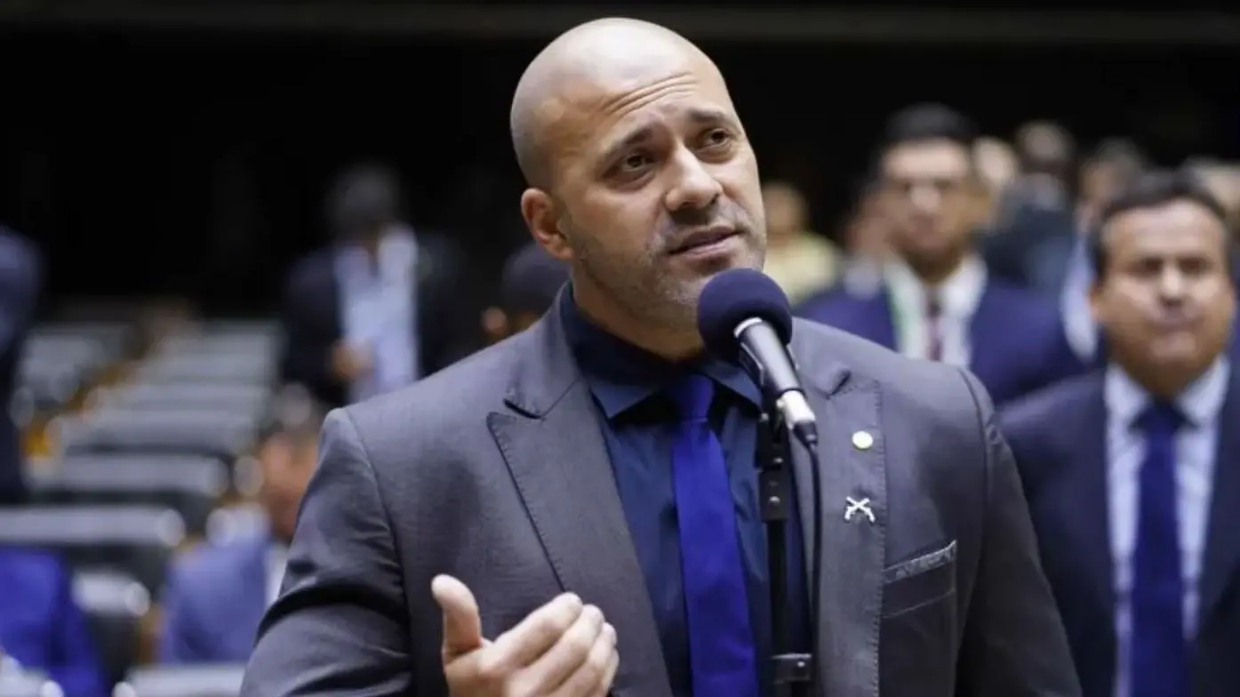 daniel silveira falando em microfone no plenário da câmara dos deputados. ele usa terno e gesticula