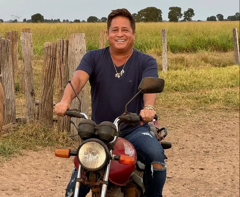 Leonardo posa para foto em cima de motocicleta em fazenda