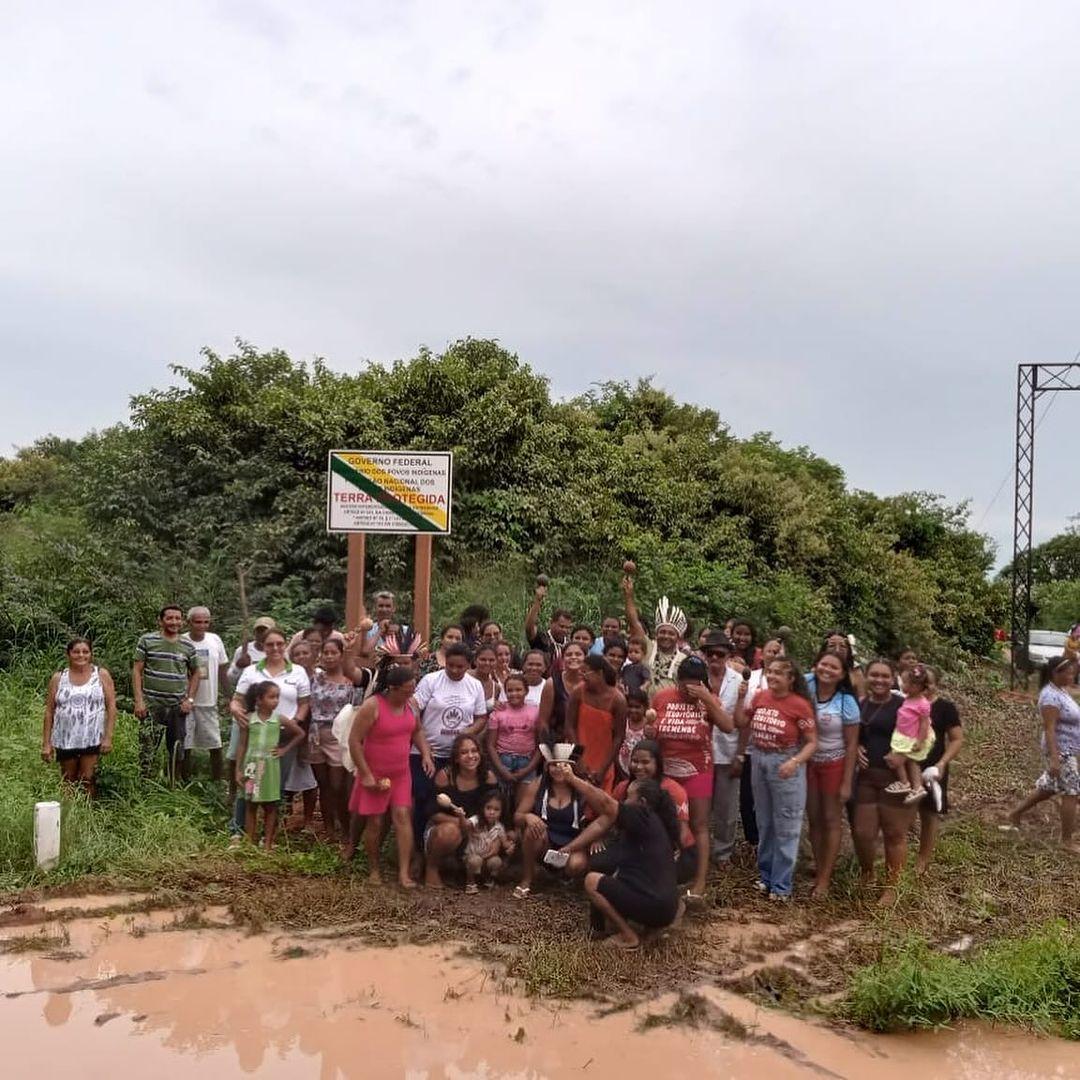 Indígenas Tremembé posam para foto em frente à placa de demarcação da Funai