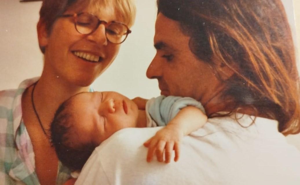 Rosina sorrindo e o marido segurando a filha recém-nascida no colo