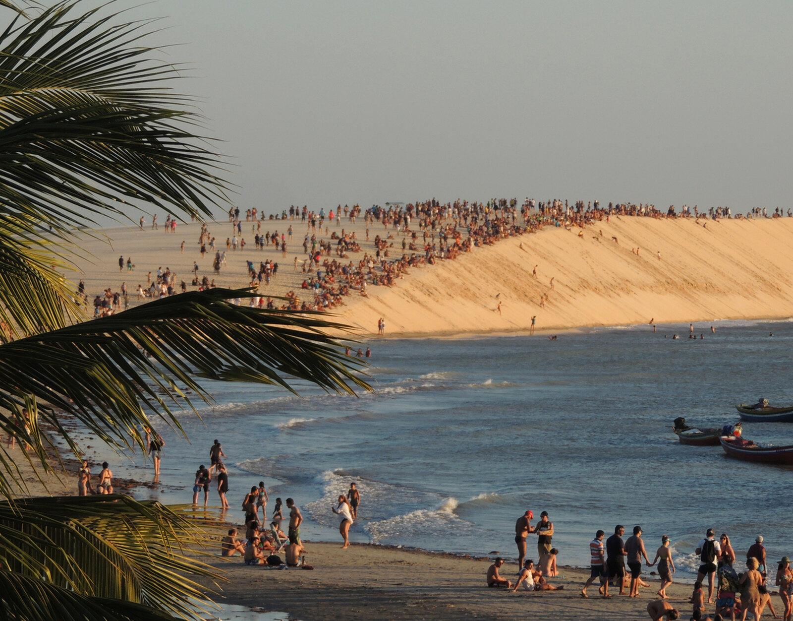 Duna do por do sol repleta de pessoas em Jeri