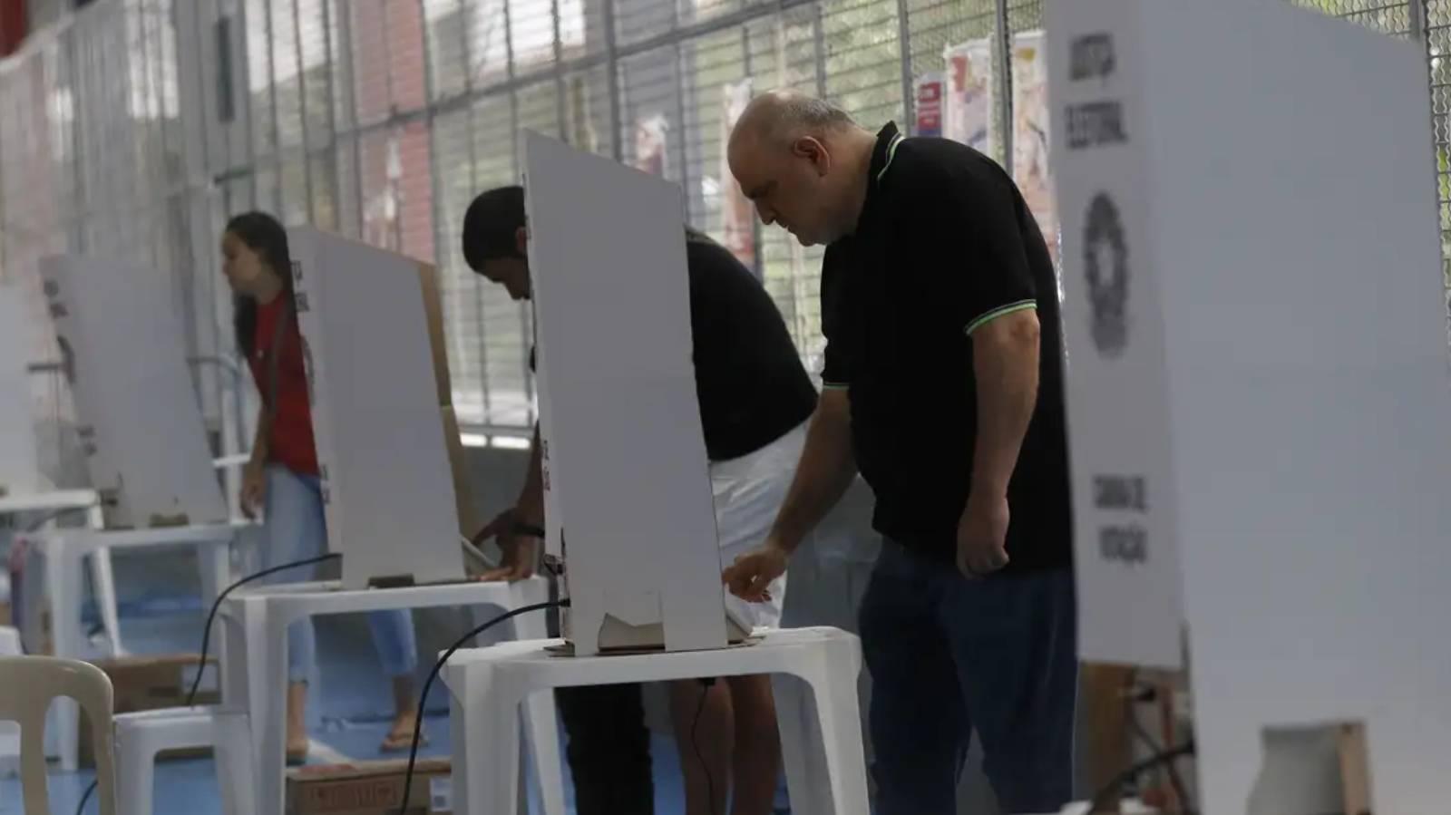 Pessoas votando. Até que horas vai à votação neste domingo (27)? Veja horário em todo o Brasil