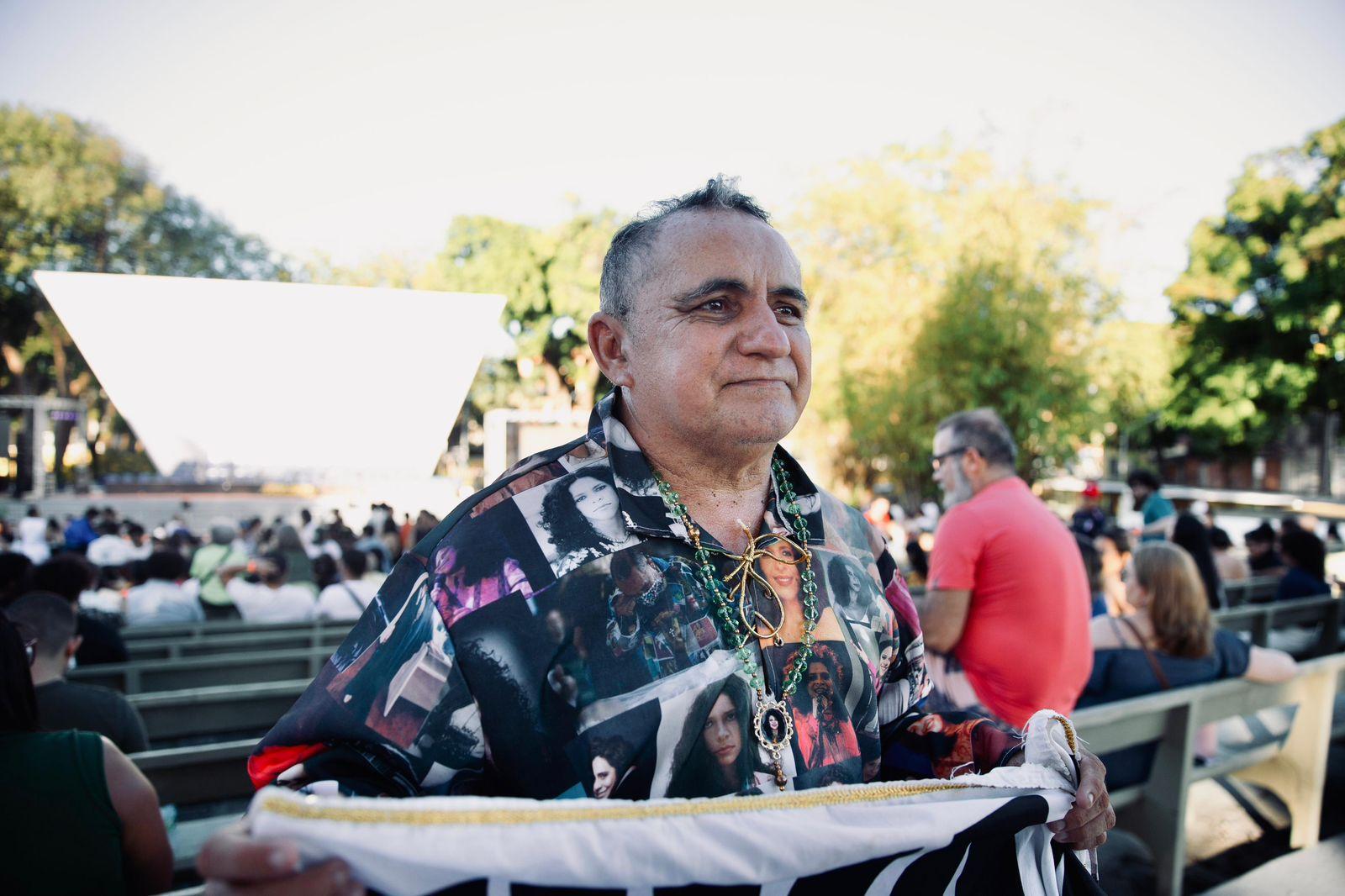 Frankley é um homem branco de cabelo grisalho e com idade em torno de 50 anos. Ele está vestindo uma camisa que homenageia Gal Costa