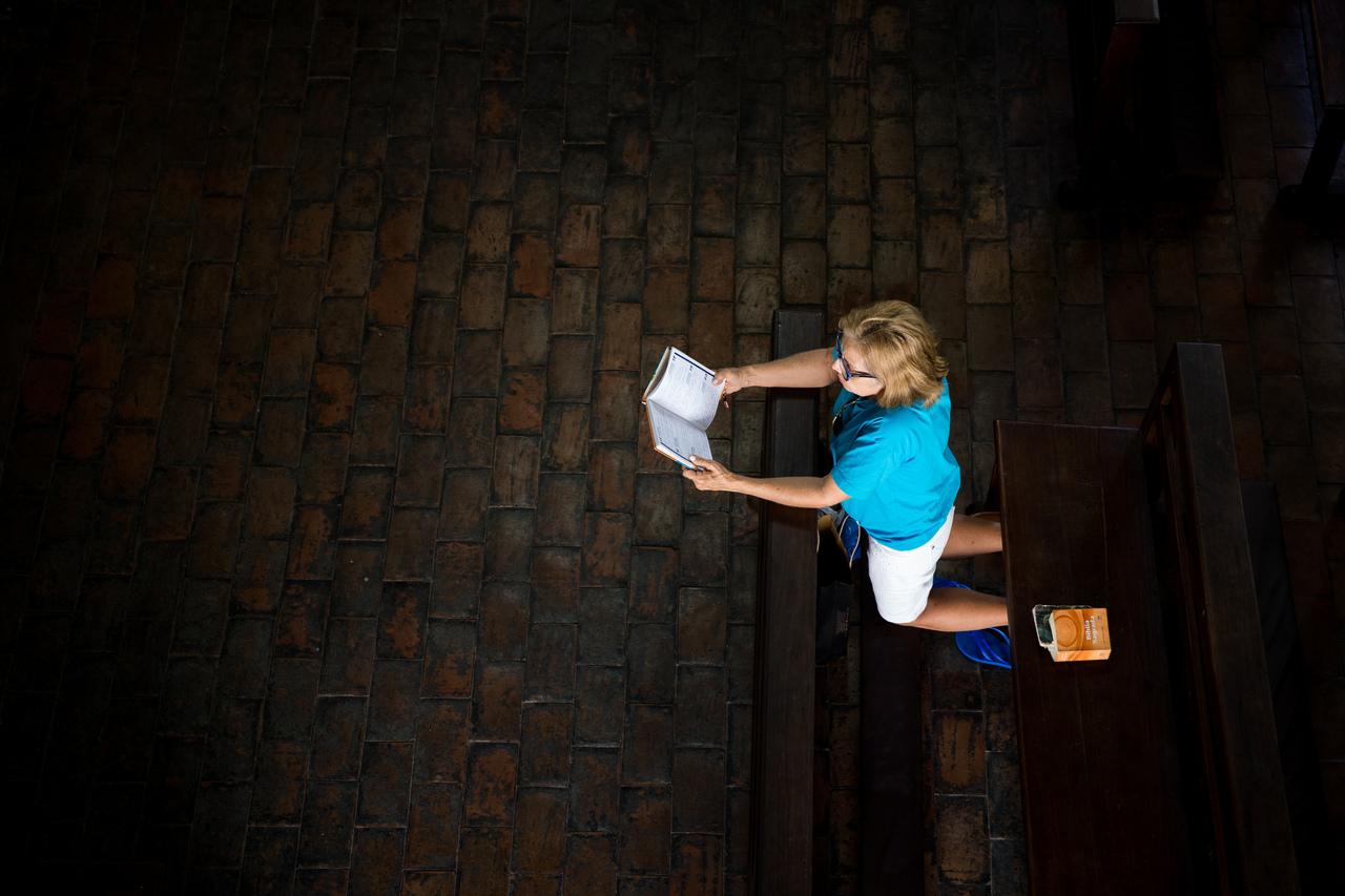 Mulher ajoelhada rezando 