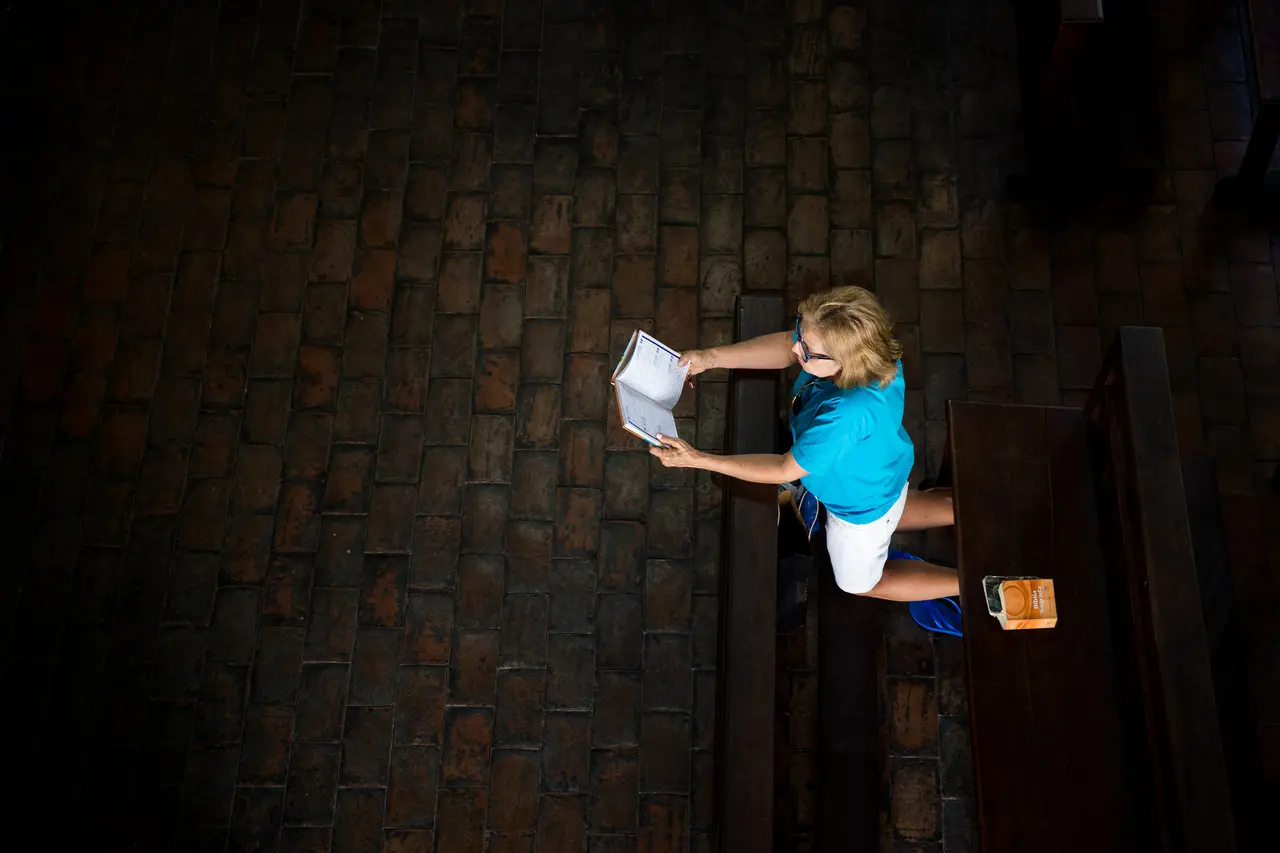 Mulher ajoelhada rezando 