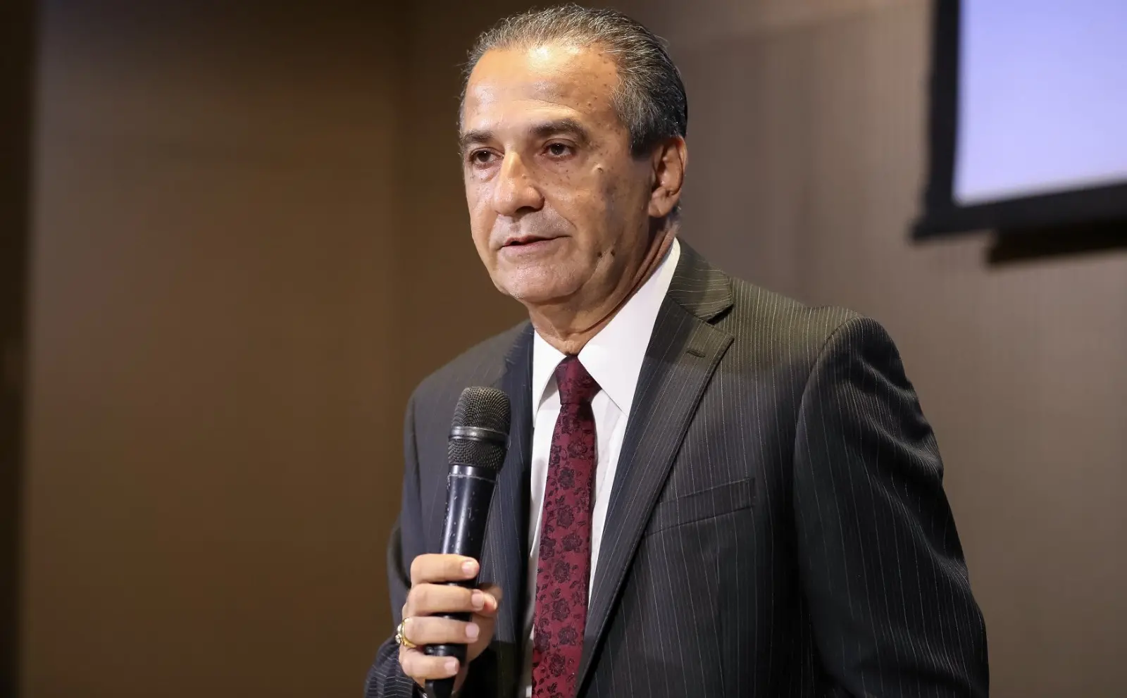 Malafaia é um homem idoso de cabelo grisalho escuro penteado para trás. Na foto, ele está de terno preto listrado, camisa social branca e gravata vermelha