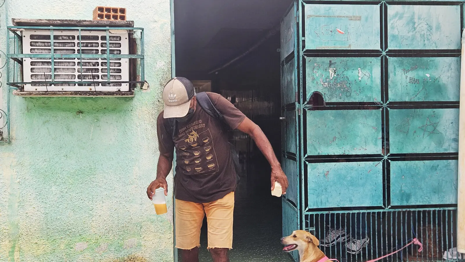 Homem saindo de Centro Pop com suco e pão