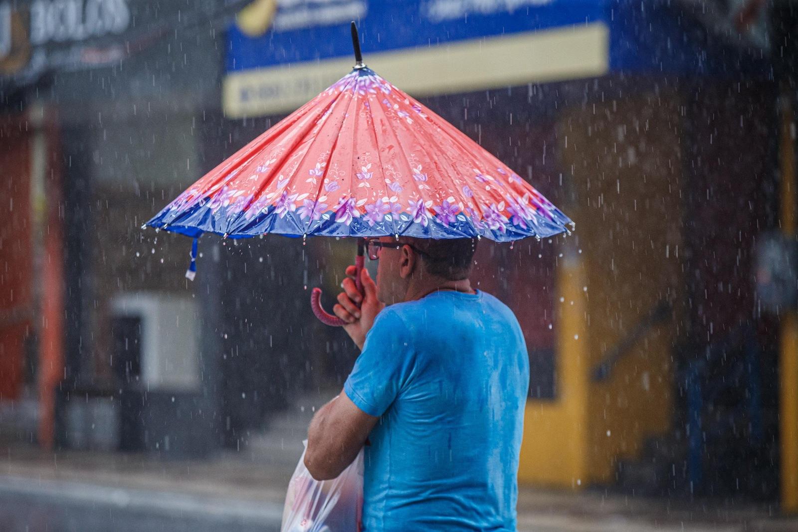 Homem segura guarda-chuva