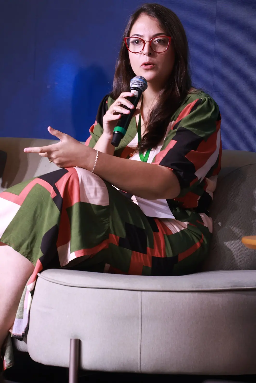 Foto da médica Bruna Bezerra Salviano em palestra segurando microfone
