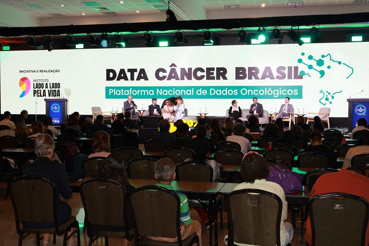 Palestra em auditório apresentando a plataforma Data Câncer Brasil