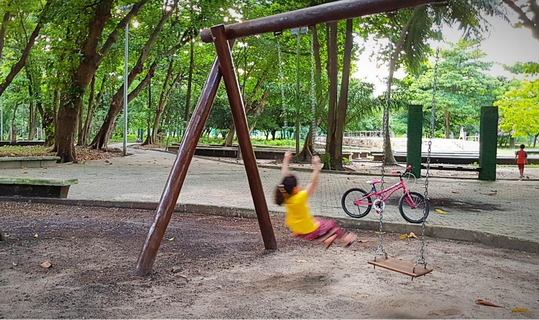 Criança brincando em balanço no parque