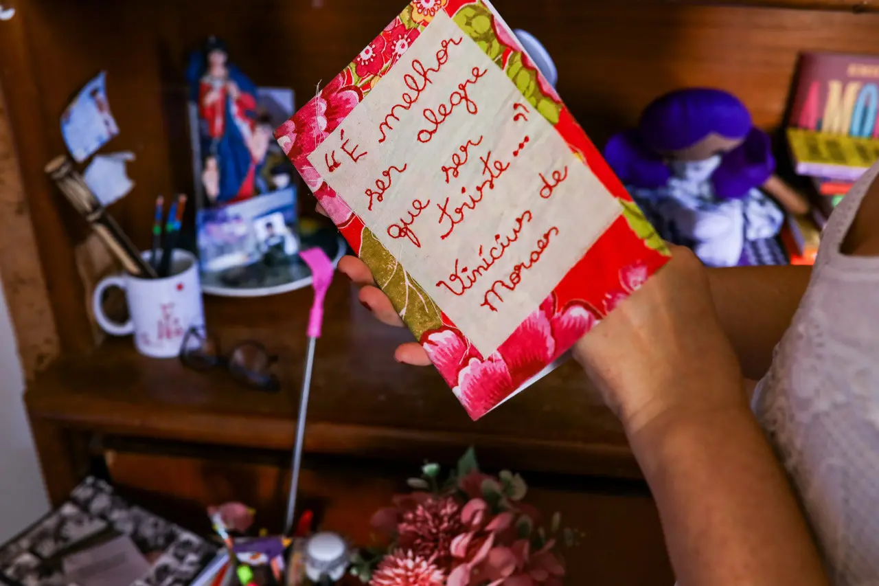 Livro com um bordado em que está escrito 