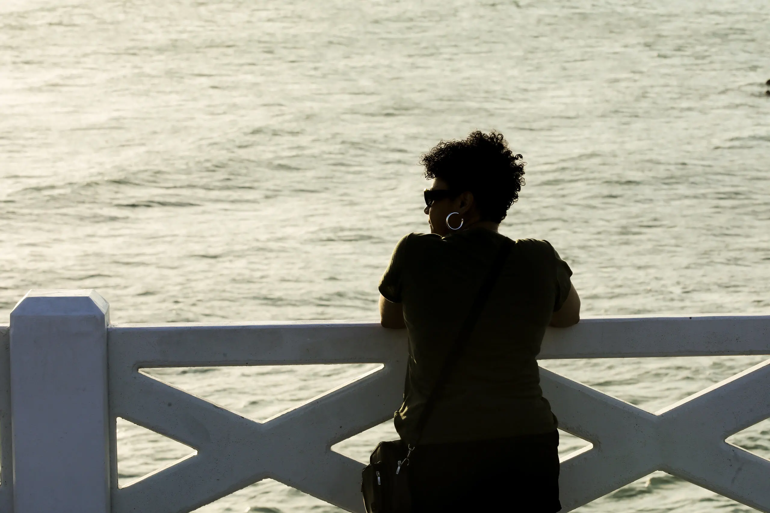 Silhueta de mulher observando o mar