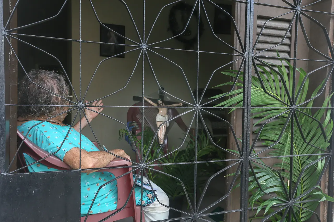 mulher idosa sentada dentro de casa