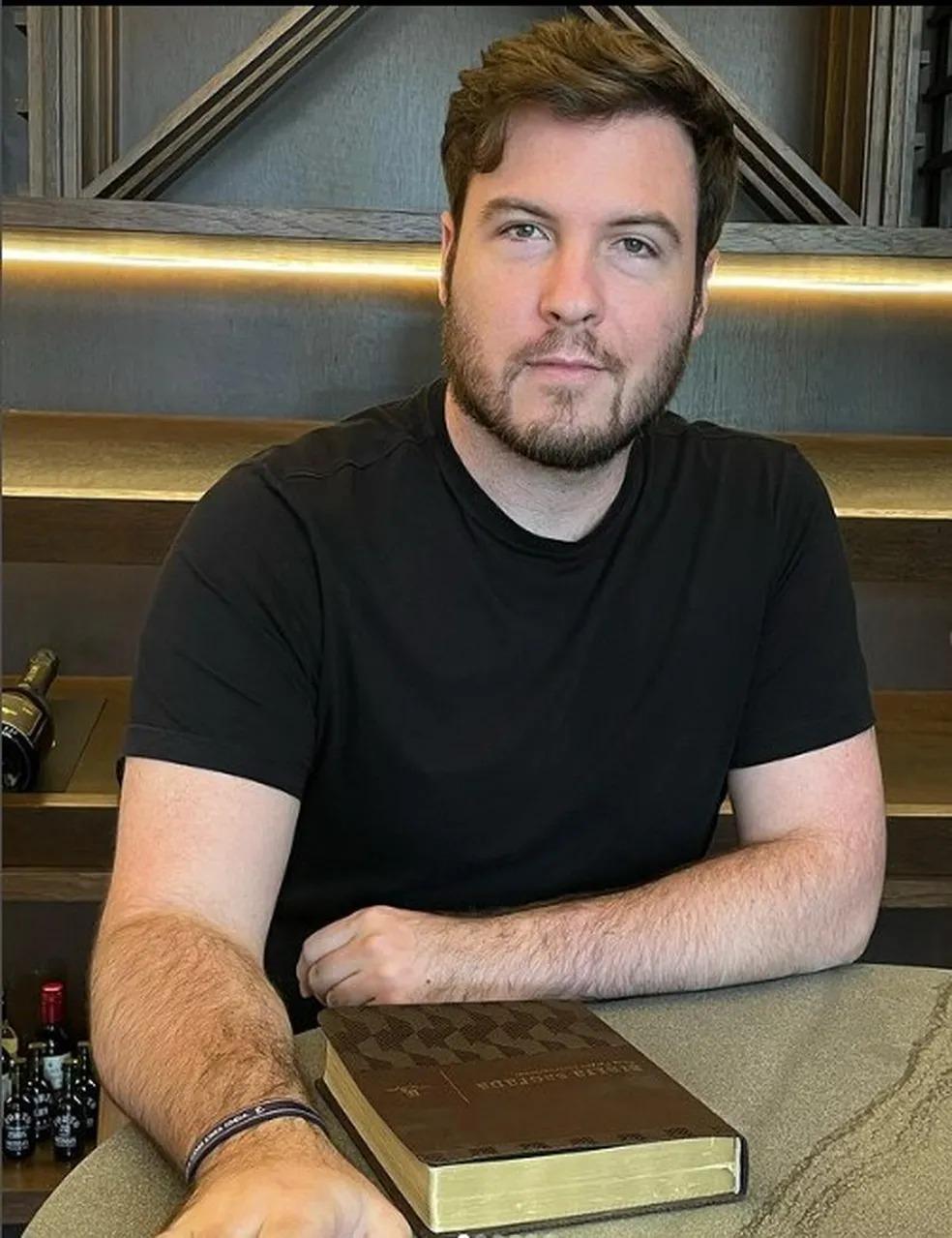 Foto de Thiago Nigro de camisa preta, influenciador que postou vídeo de feto abortado por sua esposa, Maíra Cardi