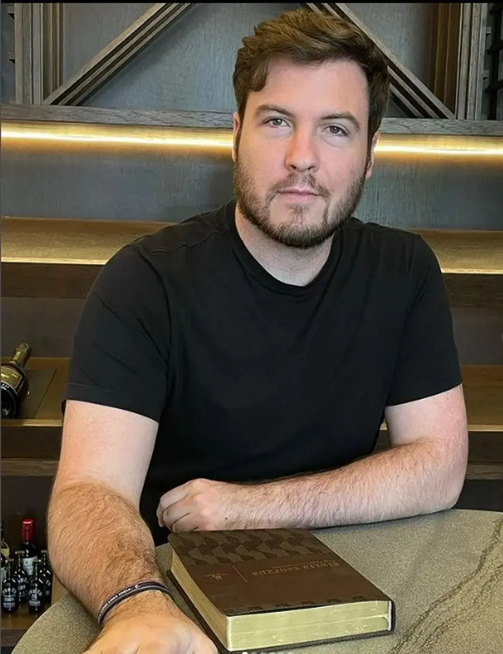 Foto de Thiago Nigro de camisa preta, influenciador que postou vídeo de feto abortado por sua esposa, Maíra Cardi