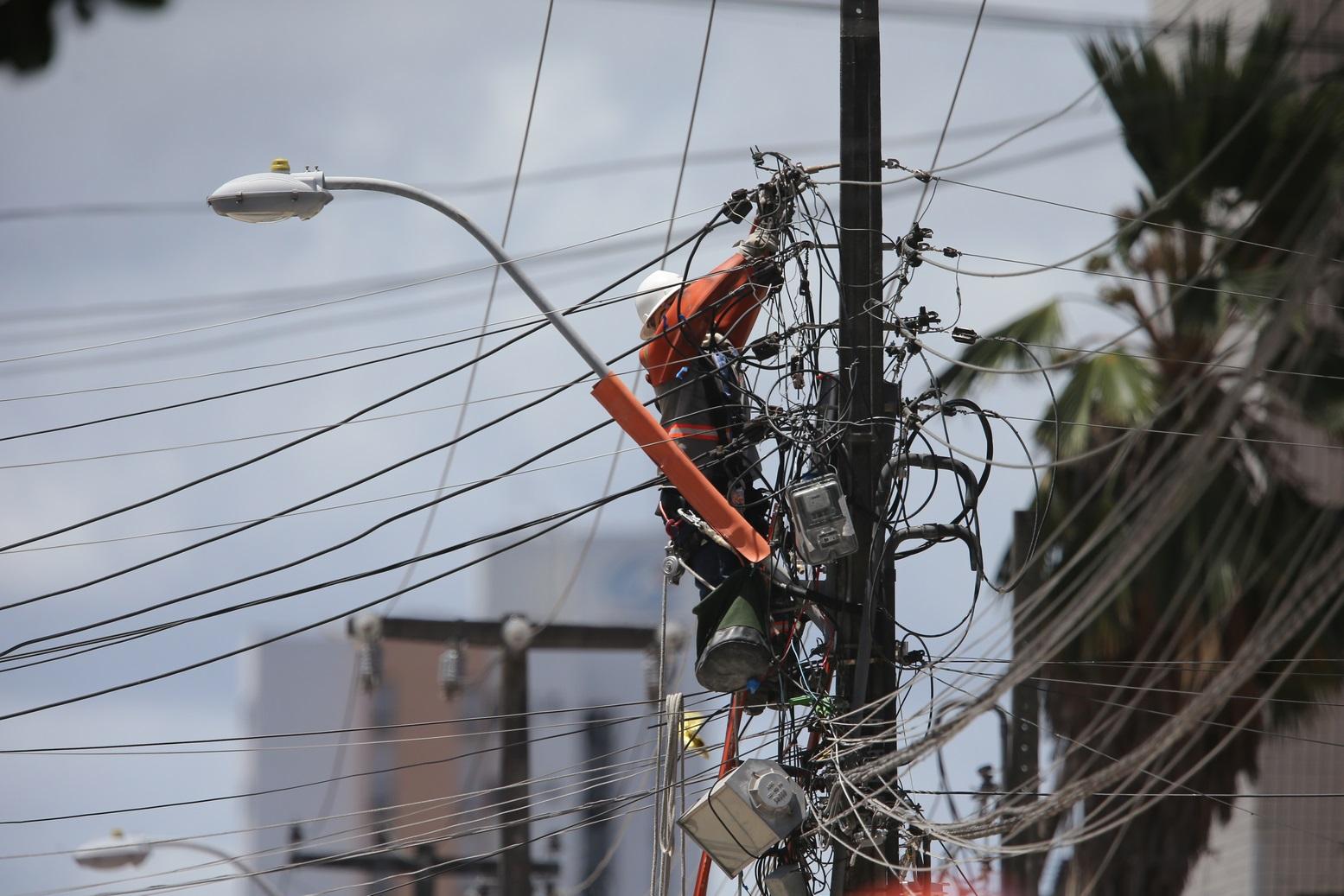 Trabalhador mexe em fiação elétrica de poste em Fortaleza