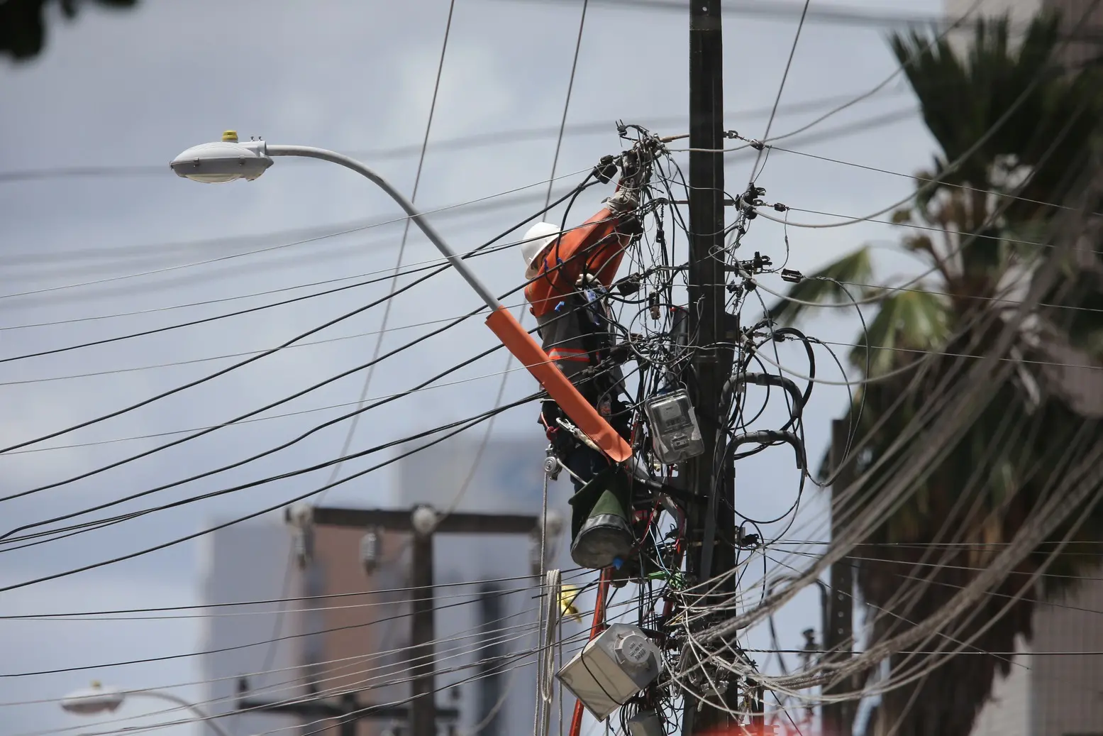 Trabalhador mexe em fiação elétrica de poste em Fortaleza