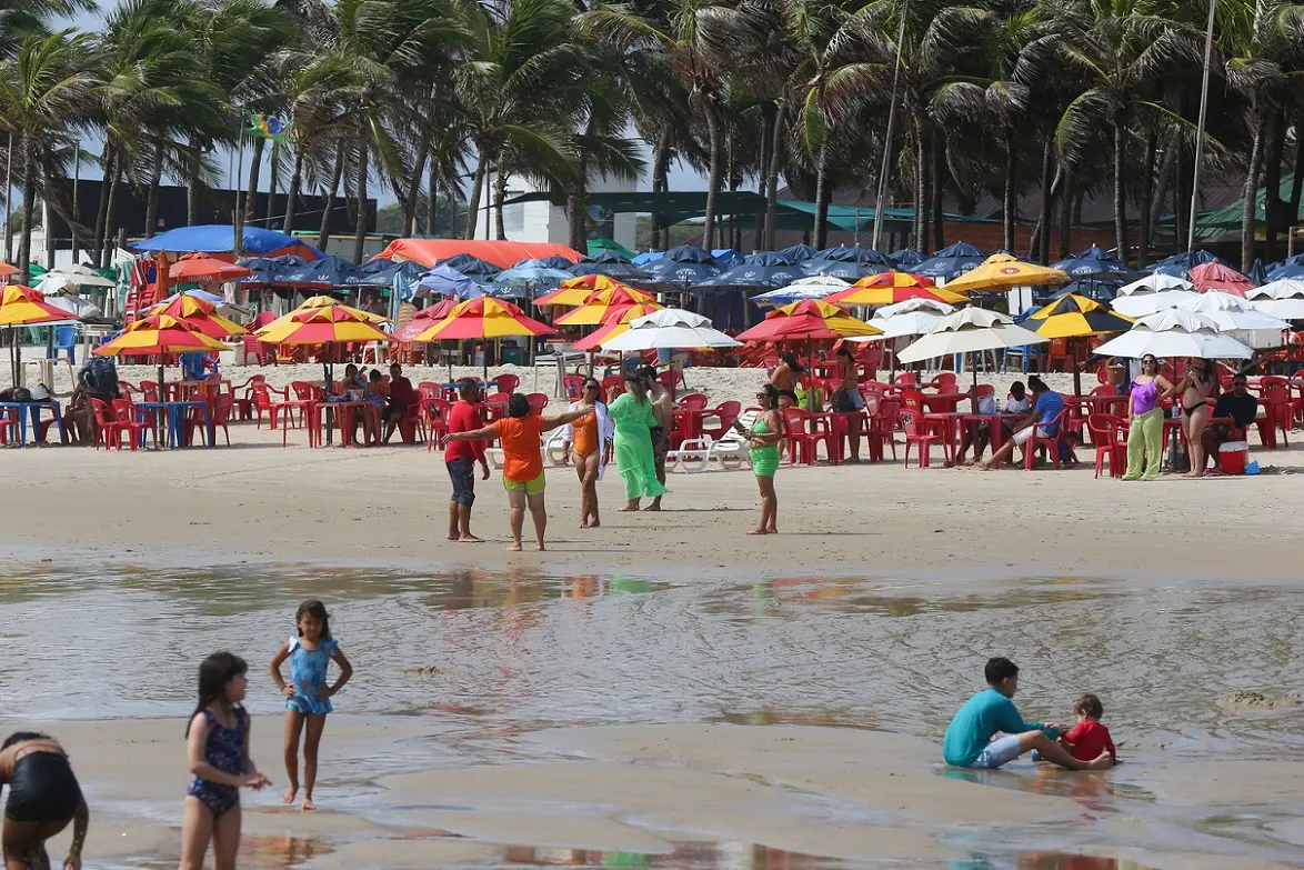 Praia do Futuro em dia de sol com pessoas e barracas na faixa de areia