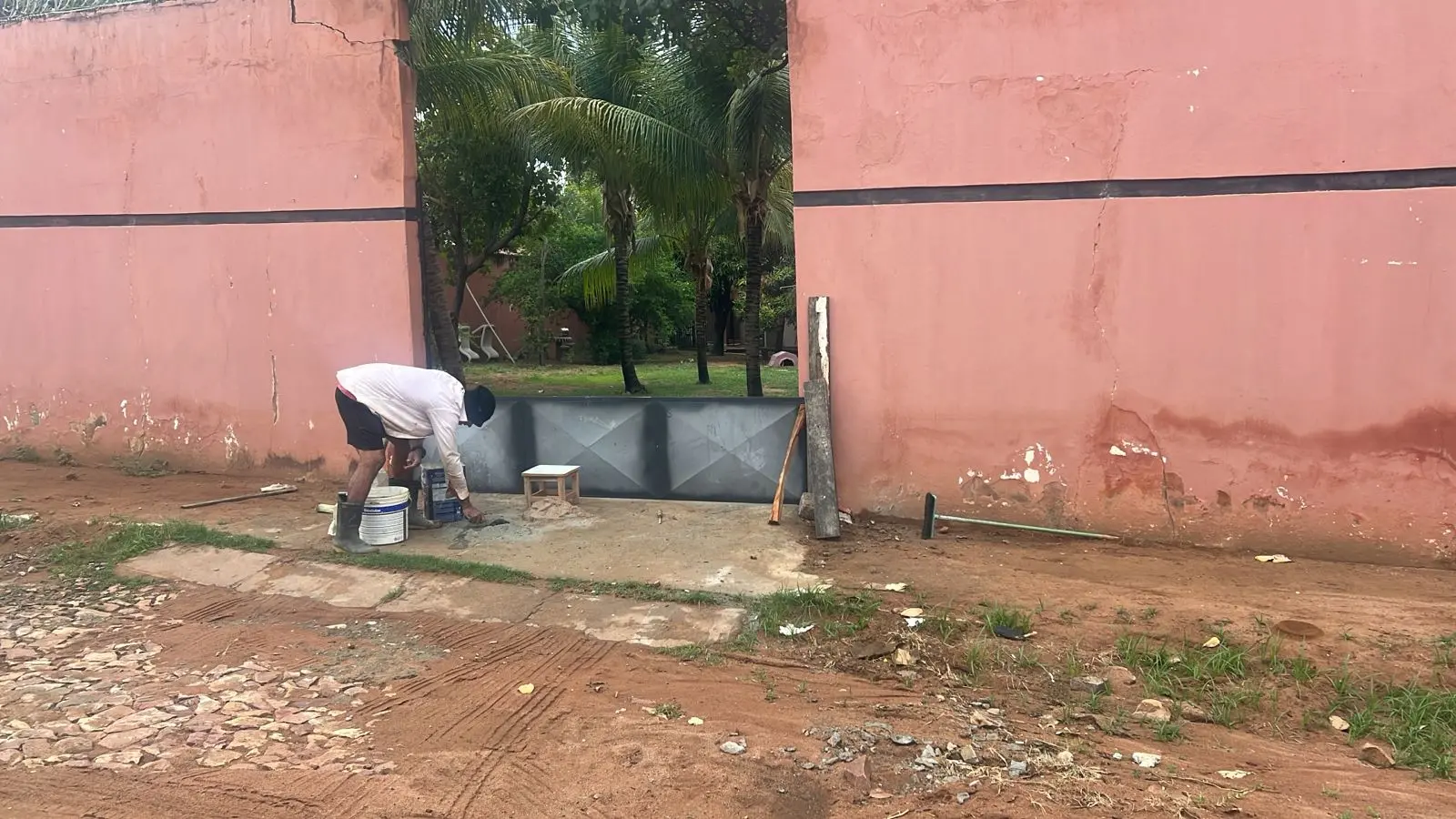 Pedreiro construindo barreira contra a chuva na porta de casa no Ceará