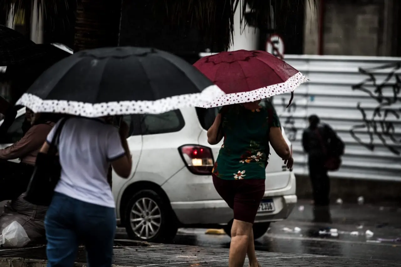 Dia chuvoso em Fortaleza e pessoas usando guarda-chuvas