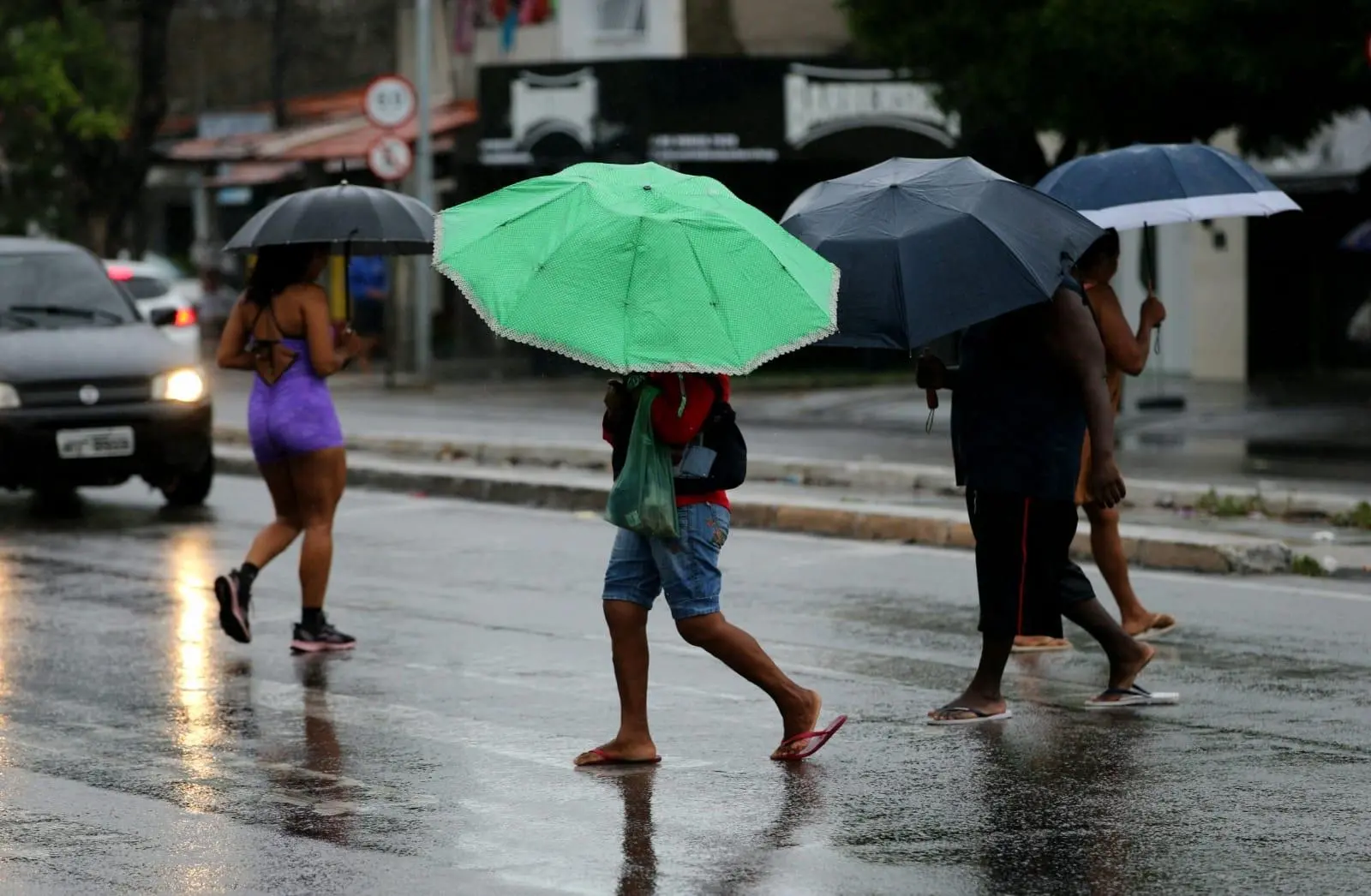 Pessoas caminhando com guarda chuva