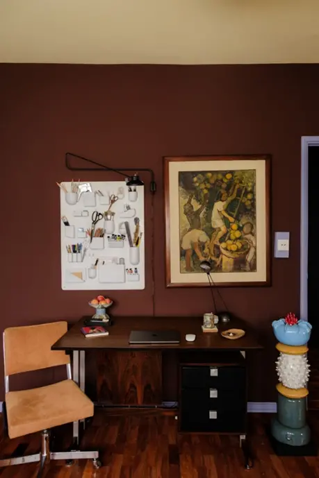 Para os mais ousados, um tom de marrom mais escuro na parede recebe quadros