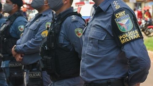 Imagem de policiais em formação, com uniformes azuis e máscaras, demonstrando força e segurança na proteção da comunidade.