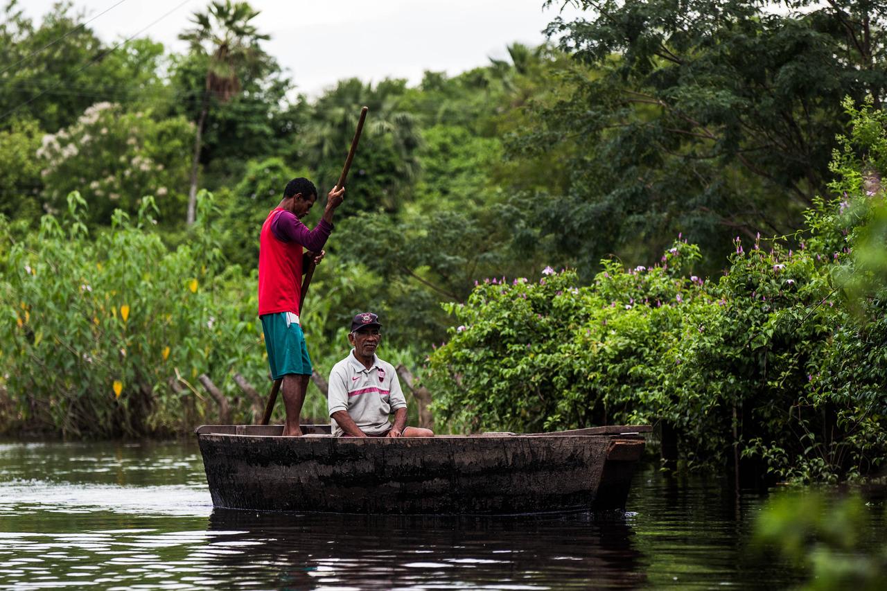 Dois homens dentro de canoa no interior de Sobral