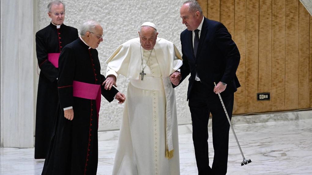 Papa Francisco recebe ajuda de dois auxiliares após o cabo de sua bengala quebrar e ele tropeçar