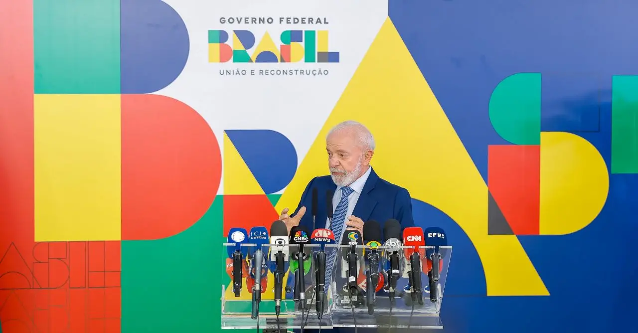lula diante de painel do governo, falando em microfones