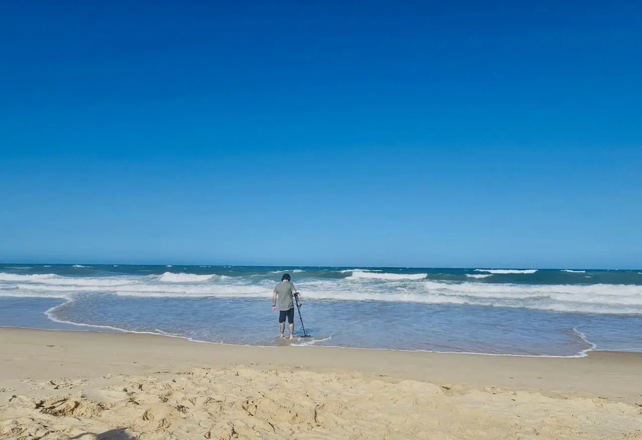 Homem usando detector de metais