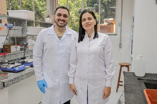 Louhana Rebouças e Thiago Moreira Melo de jaleco em laboratório