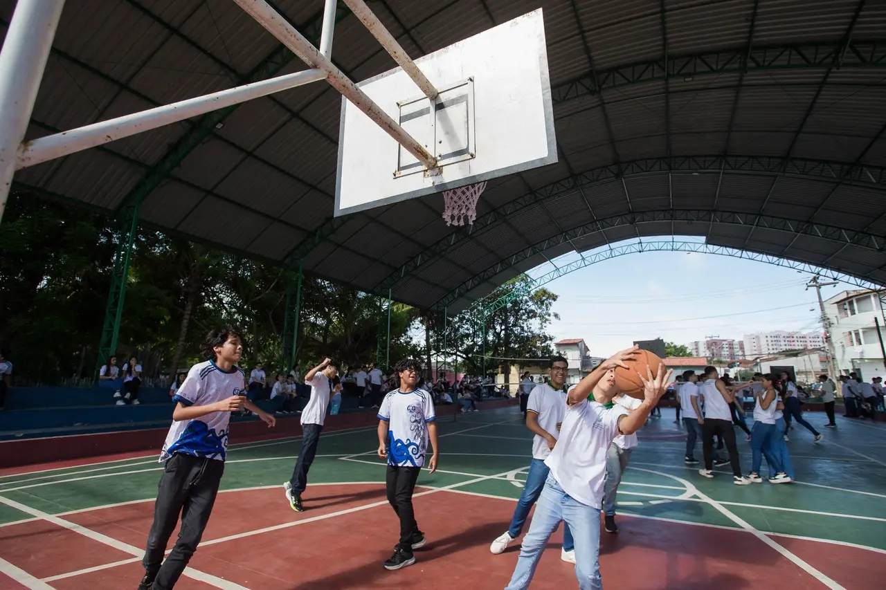 Estudantes jogando basquete na escola