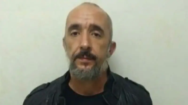 Cristian é um homem branco, calvo e de cavanhaque grisalho. Na foto, ele está sério e de camiseta preta