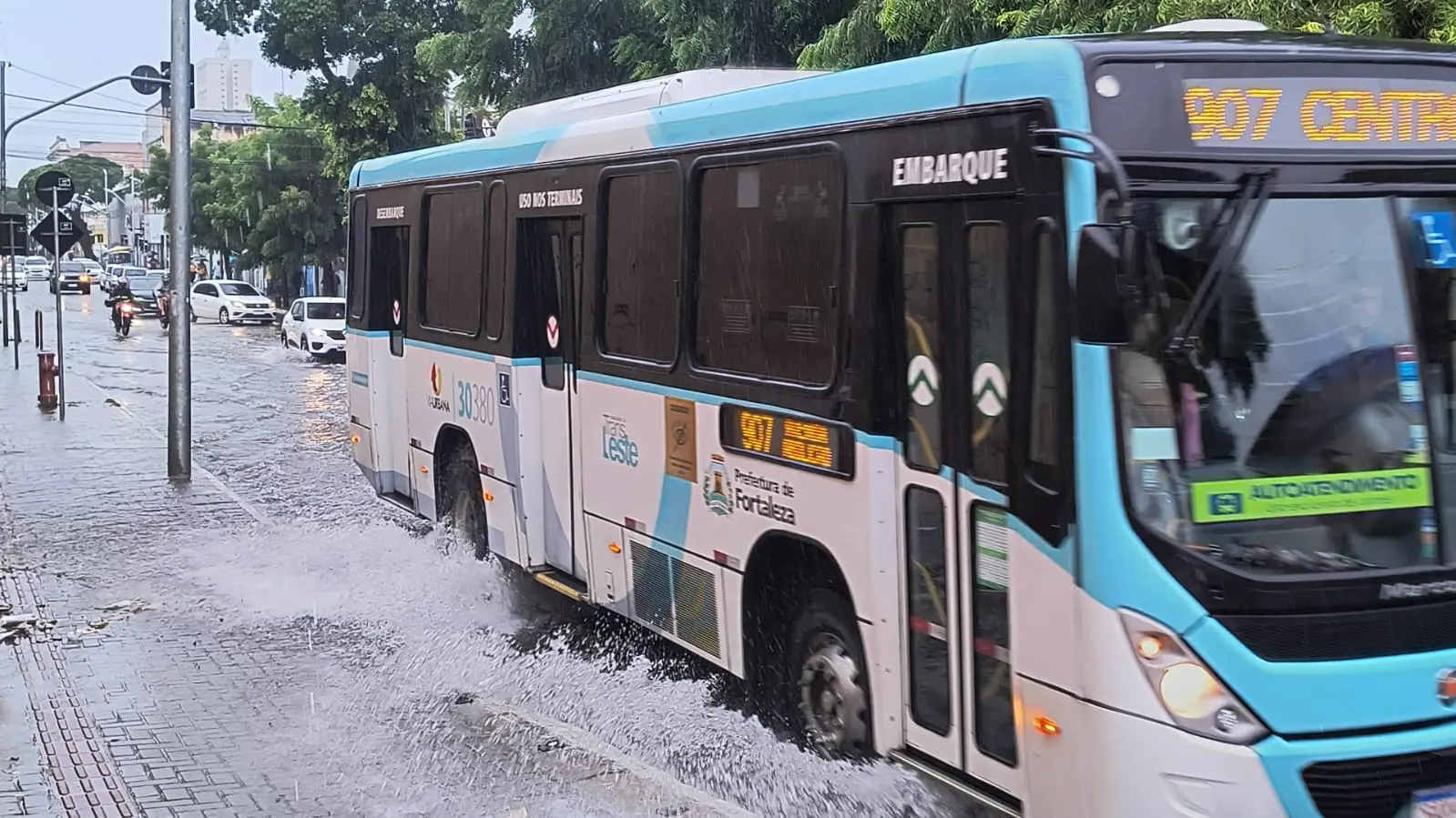 ônibus passando em rua alagada
