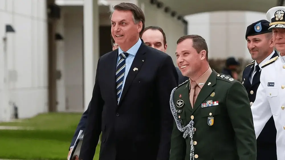 Bolsonaro e Mauro Cid caminham