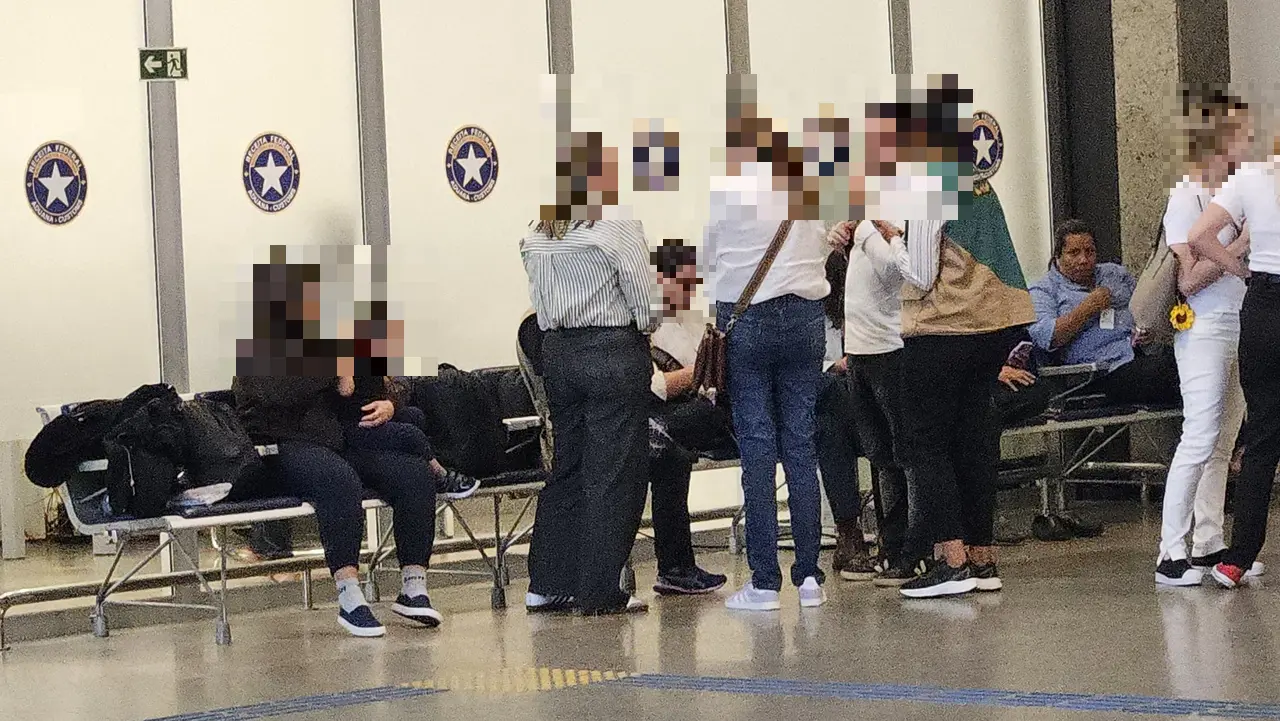 Pessoas sentadas e de pé no aeroporto