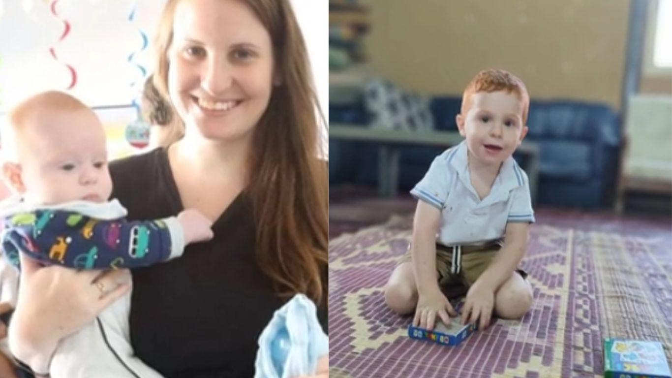 Foto de Shiri Bibas e seus dois filhos. Ela aparece segurando um bebê, junto a uma outra criança pequena brincando no chão.